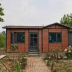 Stylish vacation container cabin by the lake with outdoor seating area, perfect for luxury resort getaways and rentals.