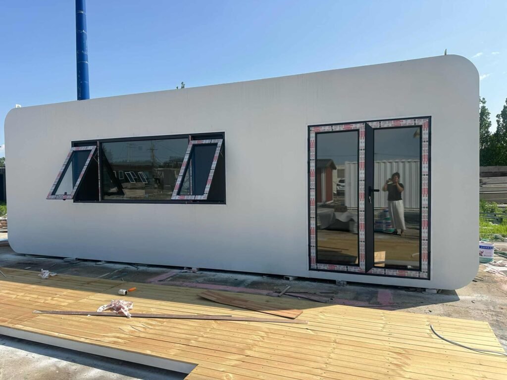White apple-shaped modular container food kiosk under construction