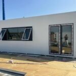 White apple-shaped modular container food kiosk under construction